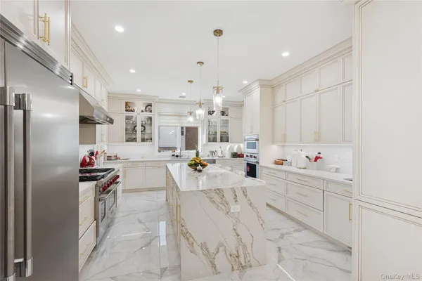 a kitchen view with stainless steel appliances kitchen island lots of counter space and view living room