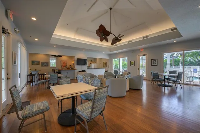 a living room with stainless steel appliances kitchen island a flat screen tv and a refrigerator