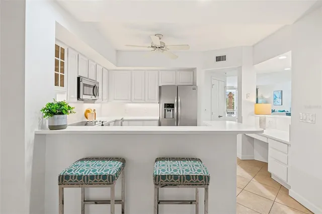 a kitchen with stainless steel appliances a table and chairs in it