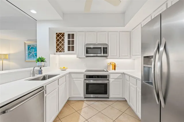 a kitchen with stainless steel appliances granite countertop a refrigerator stove top oven and sink
