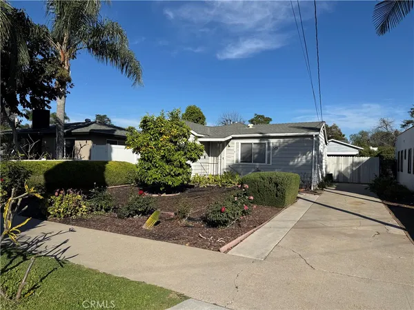 a view of a house with a yard and potted plants