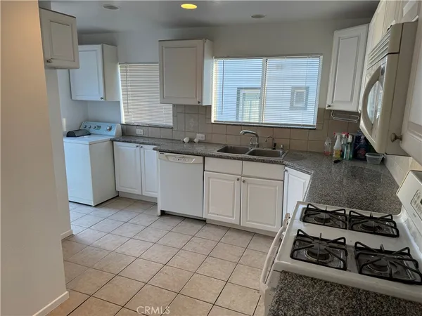 a kitchen with a sink a stove and cabinets