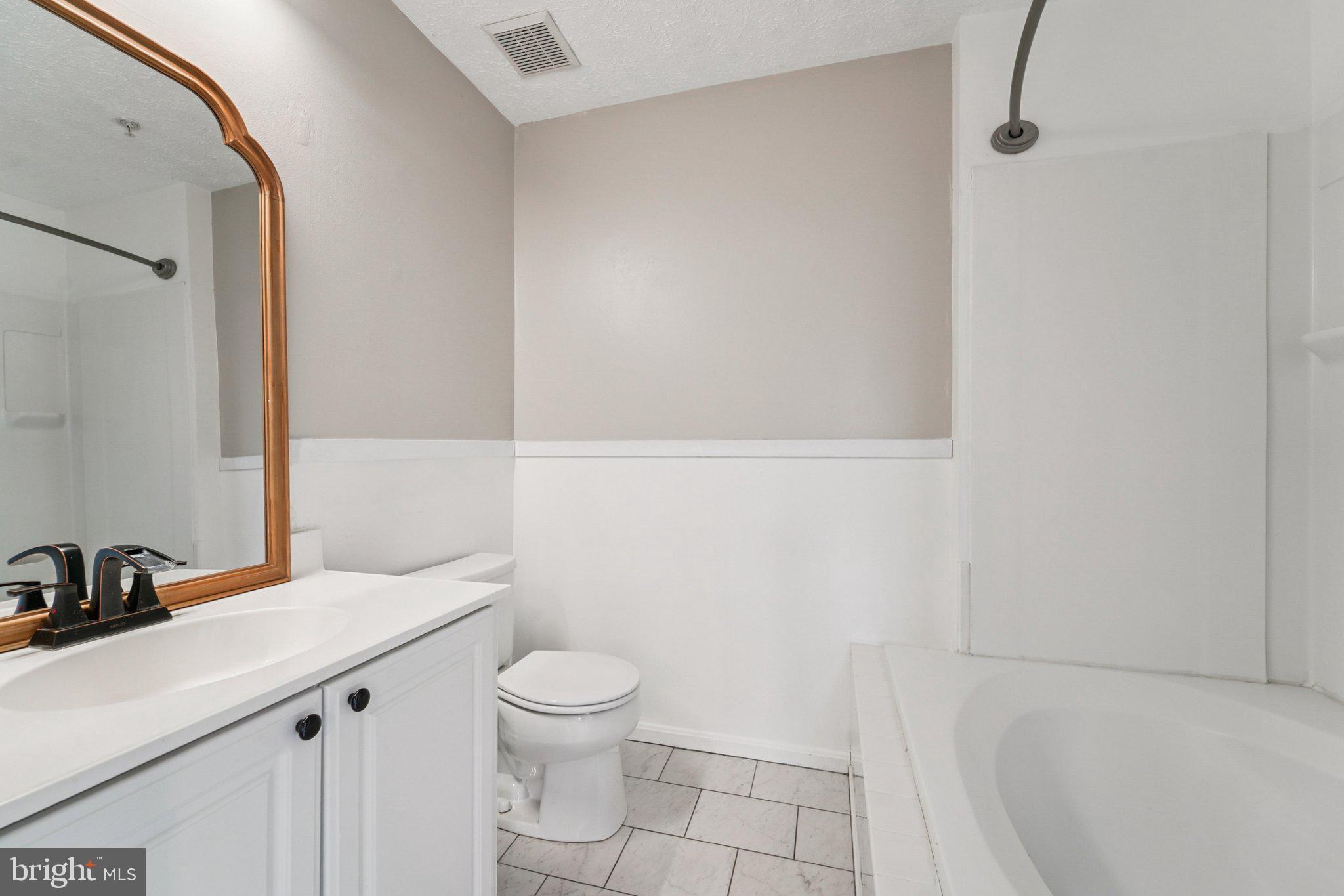 2444 Blue Spring Court, Unit 303 Odenton, MD 21113 - Photo 14 of 24 a bathroom with a sink a toilet and a mirror