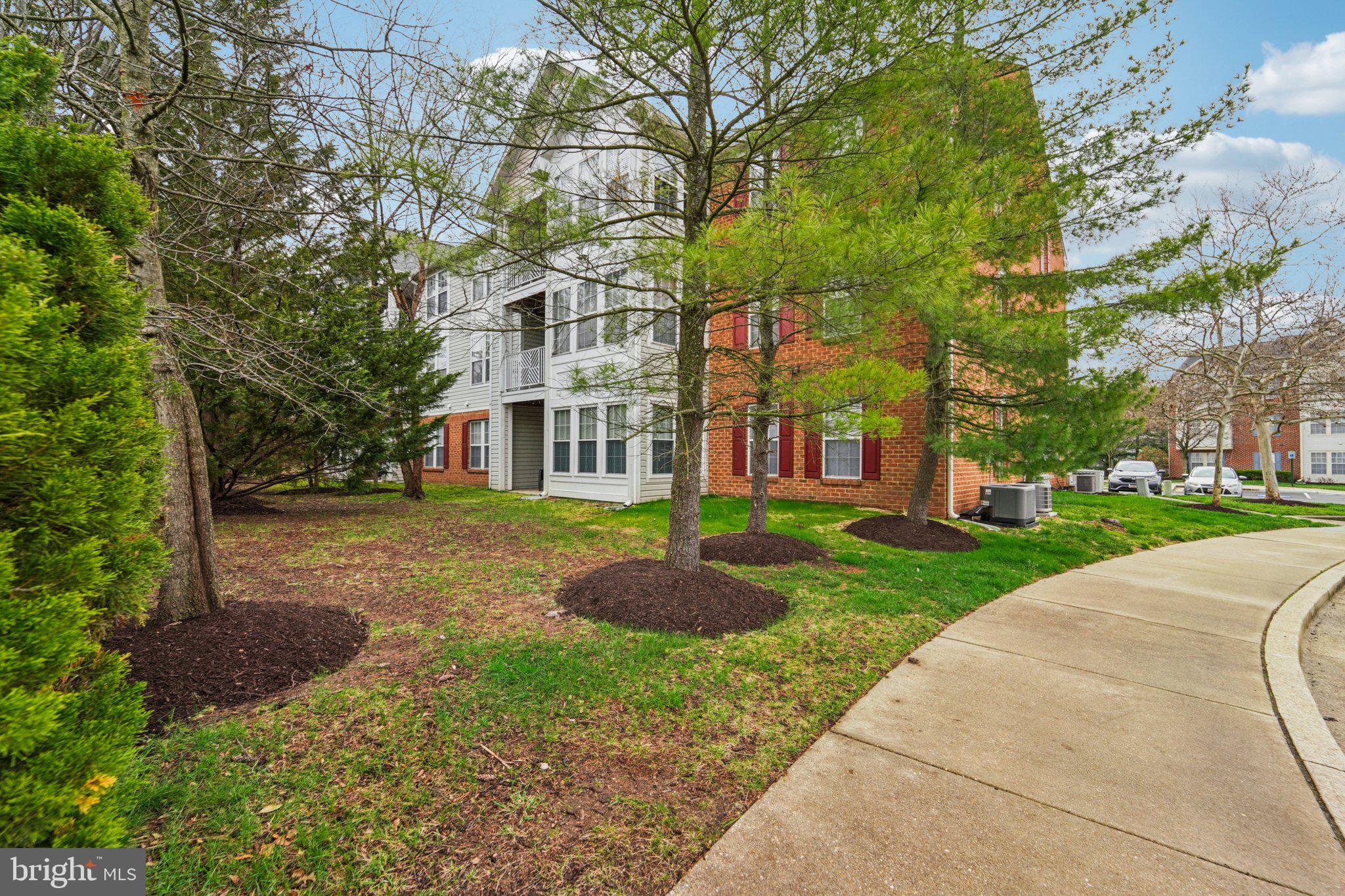 2444 Blue Spring Court, Unit 303 Odenton, MD 21113 - Photo 24 of 24 front view of a brick house with a yard