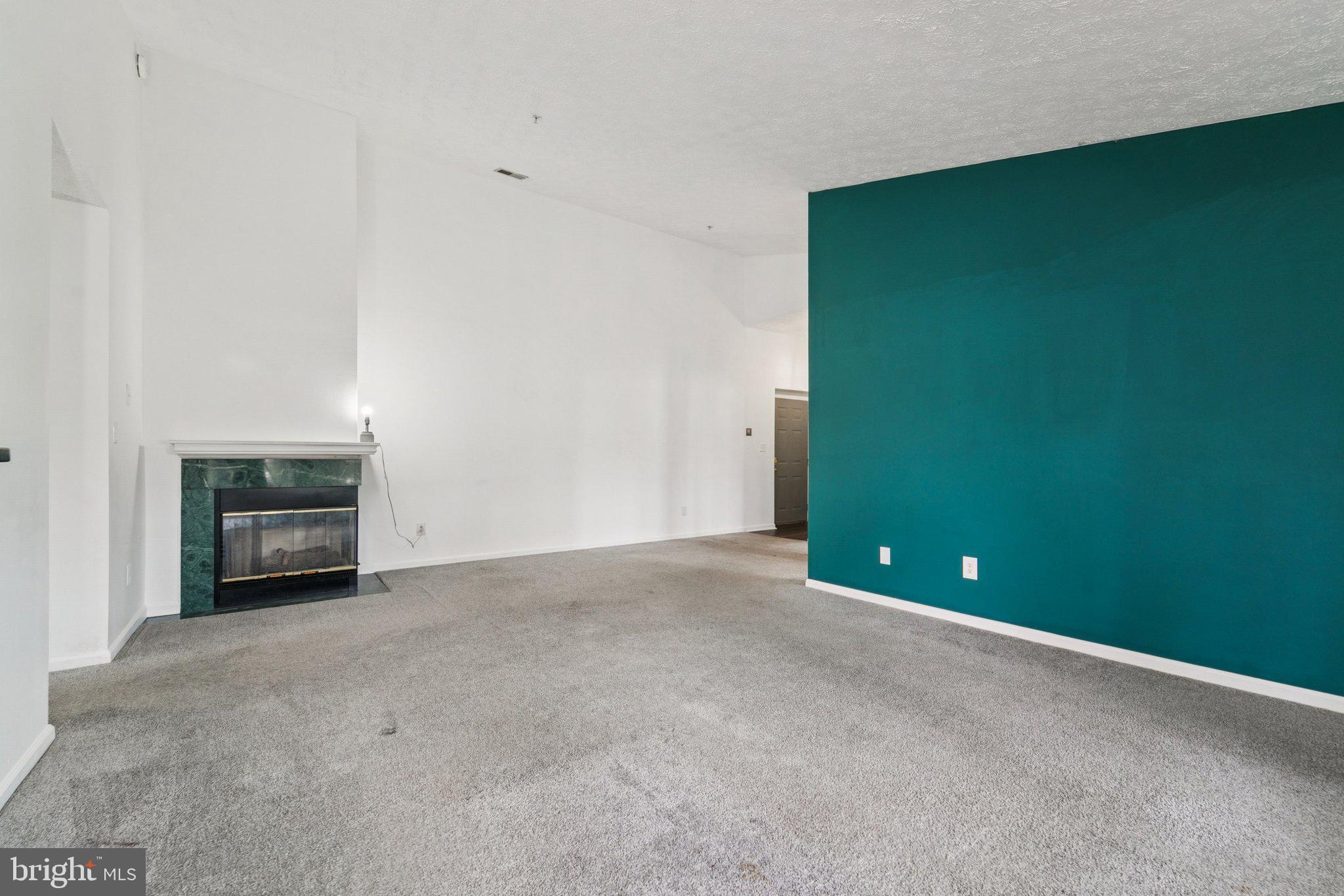 2444 Blue Spring Court, Unit 303 Odenton, MD 21113 - Photo 5 of 24 a view of an empty room with a fireplace and a window