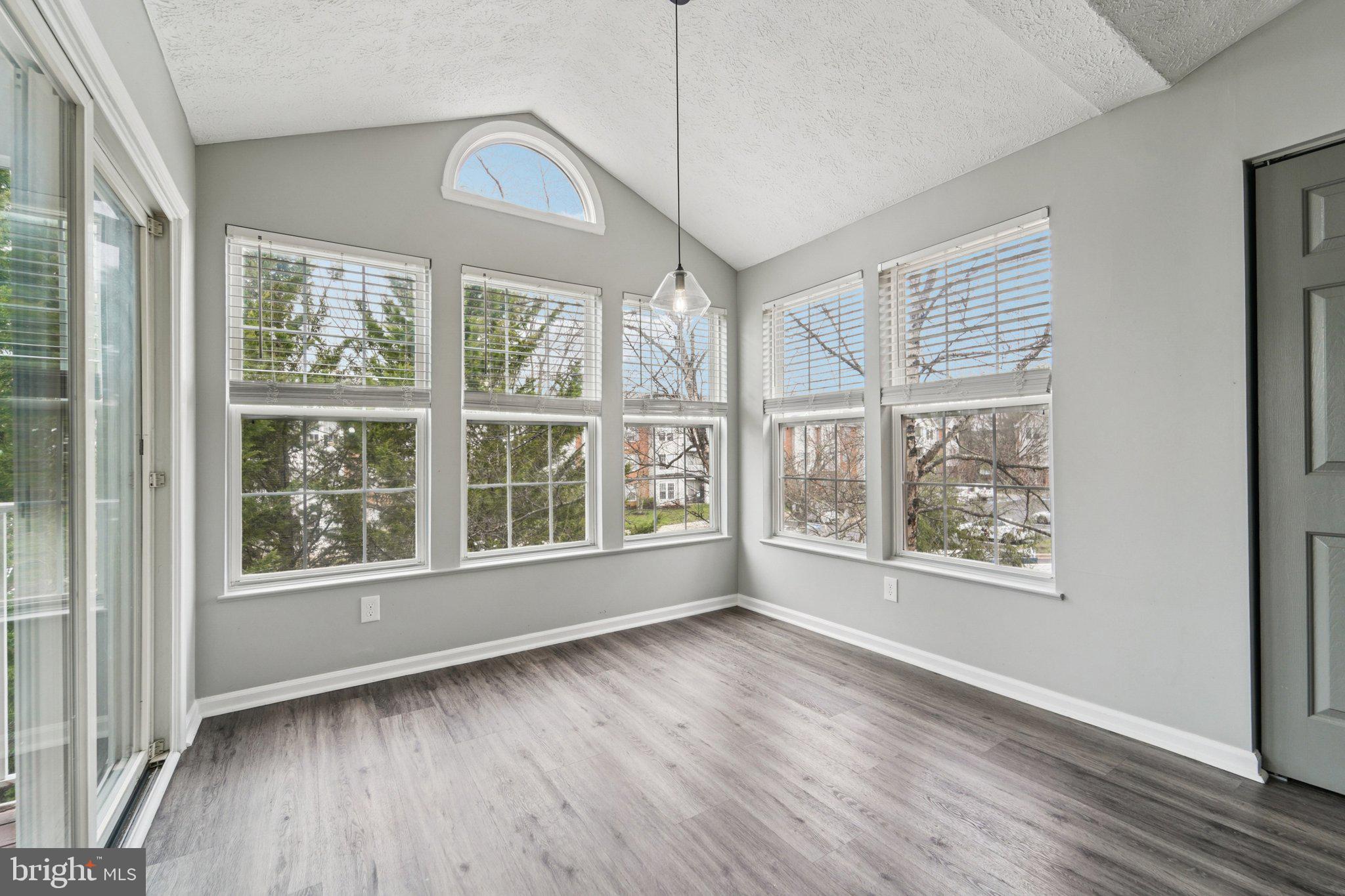 2444 Blue Spring Court, Unit 303 Odenton, MD 21113 - Photo 7 of 24 a view of an empty room with wooden floor and a window