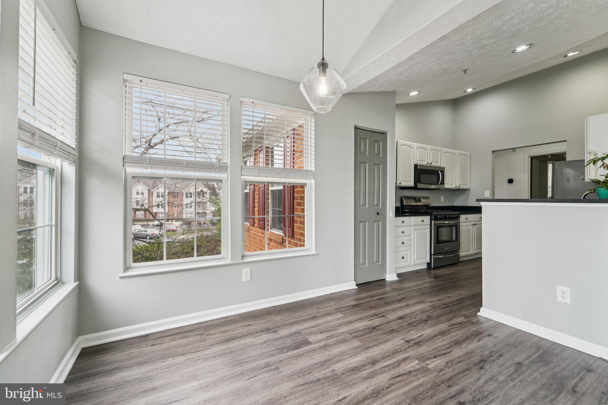 2444 Blue Spring Court, Unit 303 Odenton, MD 21113 - Photo 8 of 24 an empty room with wooden floor and windows
