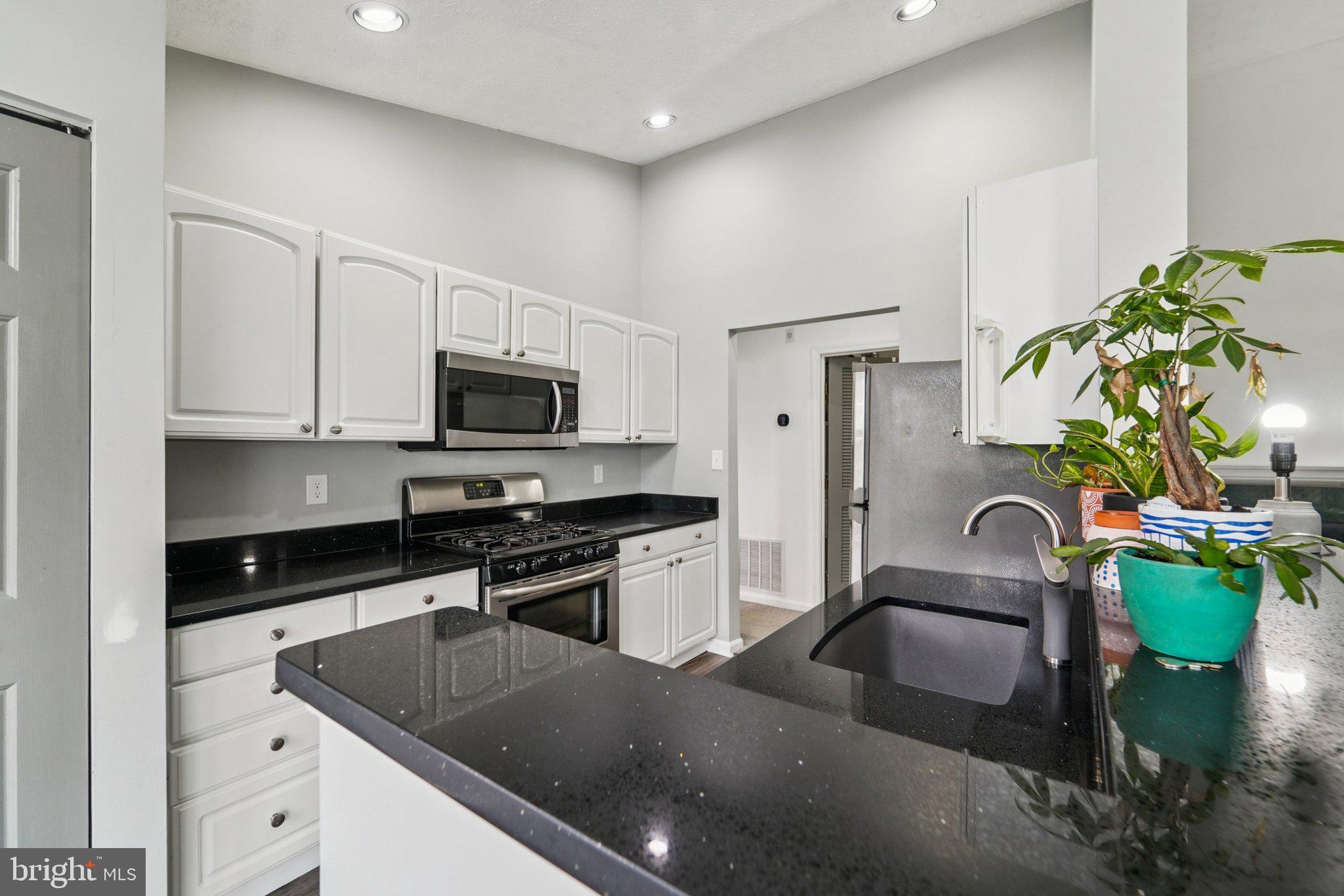 2444 Blue Spring Court, Unit 303 Odenton, MD 21113 - Photo 9 of 24 a kitchen with stainless steel appliances granite countertop a sink a stove and a refrigerator