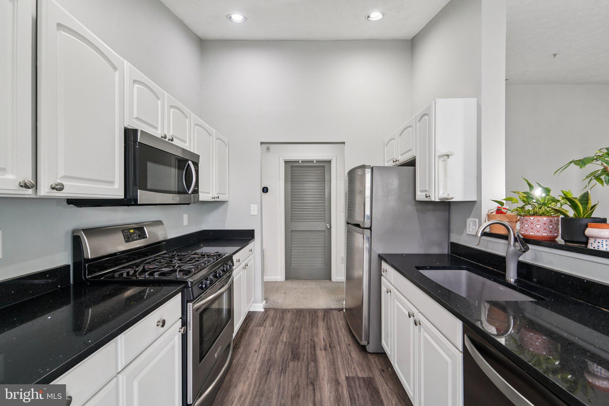 2444 Blue Spring Court, Unit 303 Odenton, MD 21113 - Photo 10 of 24 a kitchen with stainless steel appliances a sink stove microwave and refrigerator