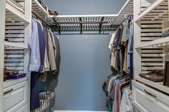 a view of walk in closet with clothes and shoes