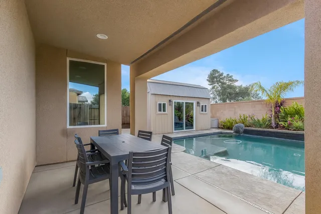 a view of a house with backyard and sitting area