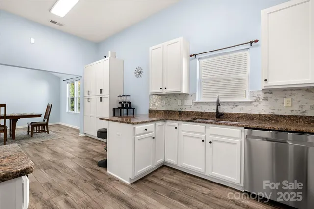 a kitchen with granite countertop white cabinets and white appliances