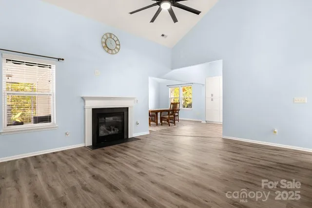 an empty room with windows and fireplace