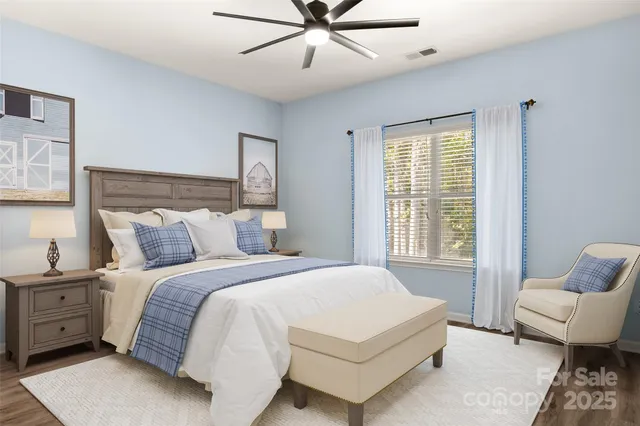 a spacious bedroom with a bed and chair