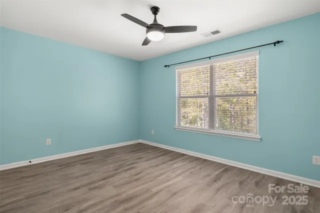 a view of a room with wooden floor and windows