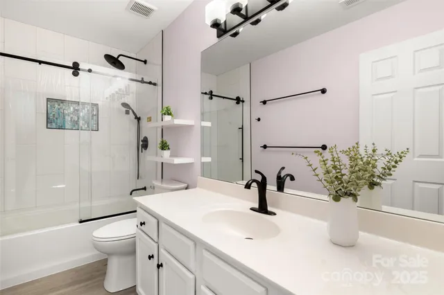 a bathroom with a sink a toilet and shower