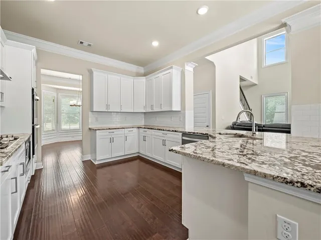 a kitchen with a sink cabinets and wooden floor