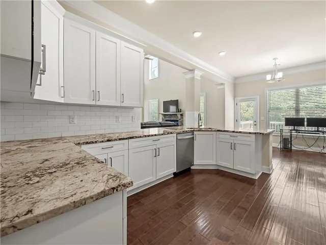 a kitchen with granite countertop white cabinets and white appliances