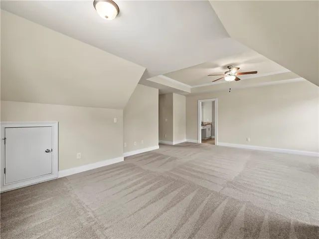 a view of an empty room with a chandelier fan