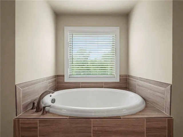 a white bath tub sitting in a bathroom next to a window