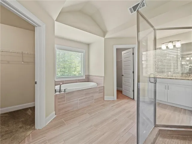 a bathroom with a tub shower and sink