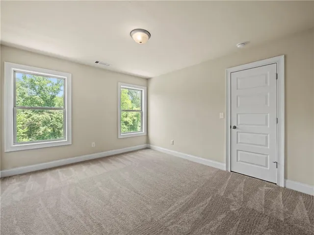 an empty room with windows and closet