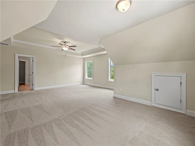 a view of an empty room with a chandelier fan