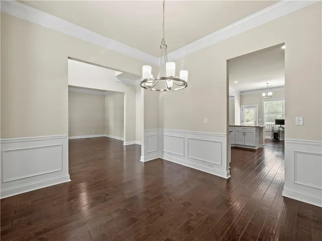 a view of a livingroom with wooden floor a ceiling fan and windows