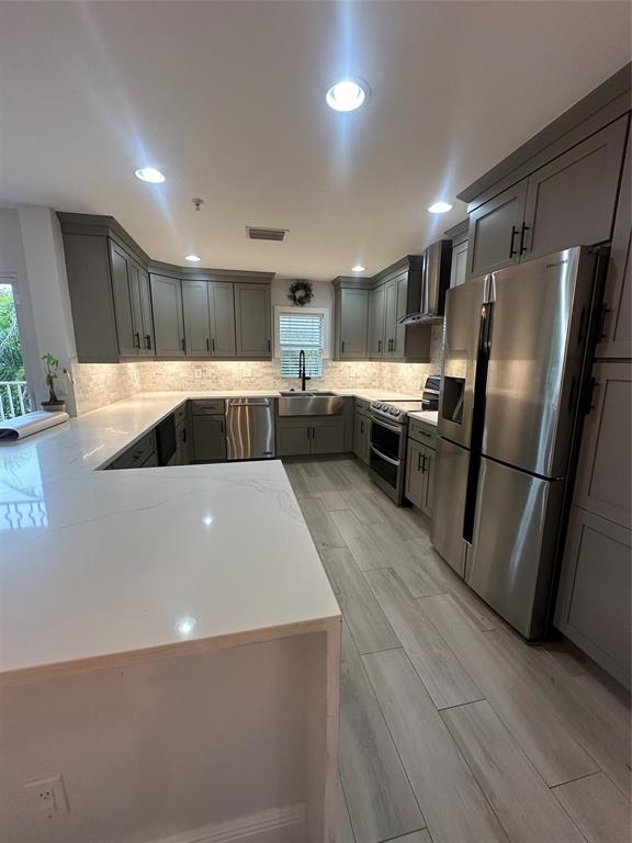 a kitchen with stainless steel appliances a refrigerator a sink a stove a microwave and a refrigerator