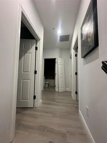 a view of a hallway with wooden floor and staircase