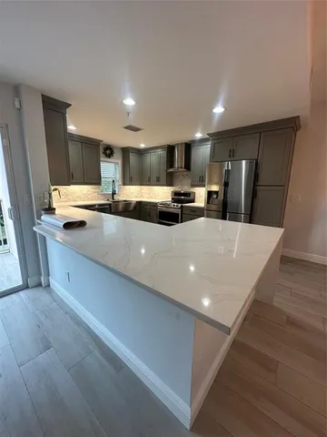 a kitchen with stainless steel appliances a refrigerator sink and microwave