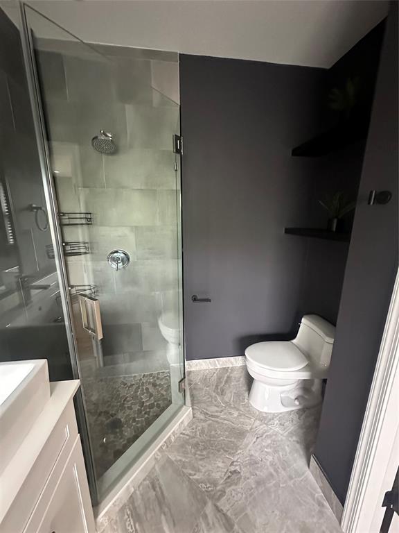 445 Northeast 1st Street Pompano Beach, FL 33060 - Photo 22 of 24 a bathroom with a granite countertop shower and a toilet