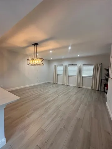 an empty room with wooden floor and window