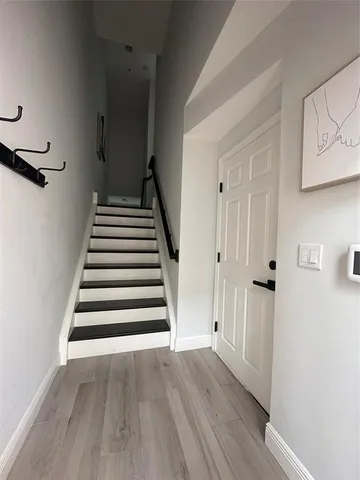a view of a hallway with wooden floor and entryway