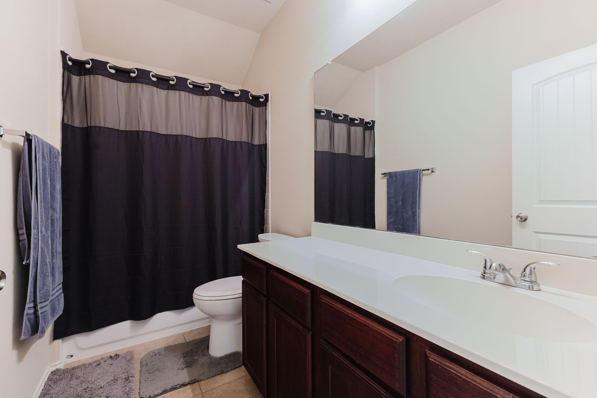 2292 Intrepid Drive Buda, TX 78610 - Photo 16 of 38 Bathroom featuring vanity, light tile patterned floors, and shower / bath combination with curtain