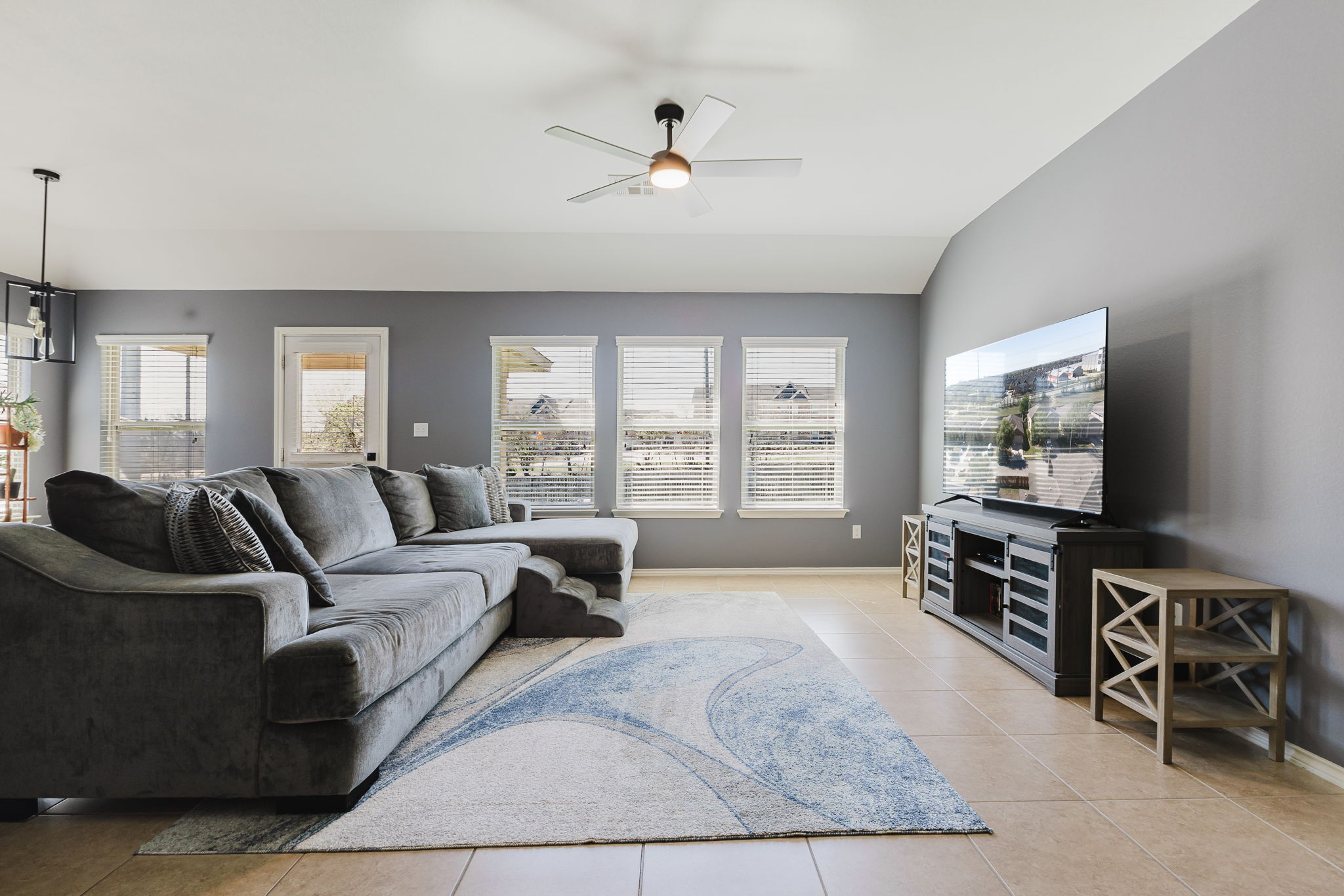 2292 Intrepid Drive Buda, TX 78610 - Photo 2 of 38 Living room featuring a ceiling fan, light tile patterned flooring, and lofted ceiling