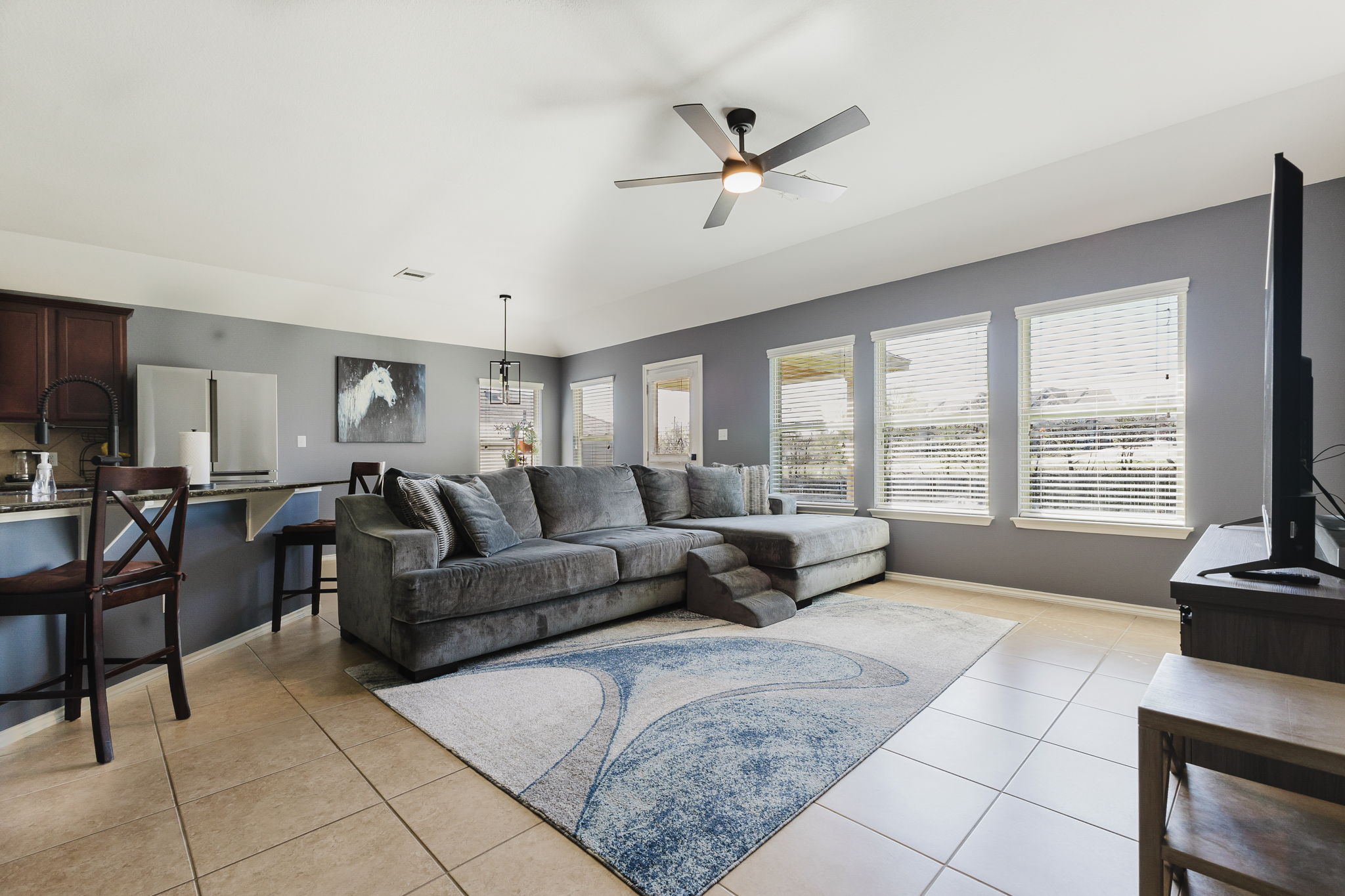 2292 Intrepid Drive Buda, TX 78610 - Photo 27 of 38 Living room featuring light tile patterned flooring, a ceiling fan, plenty of natural light, and hanging lights