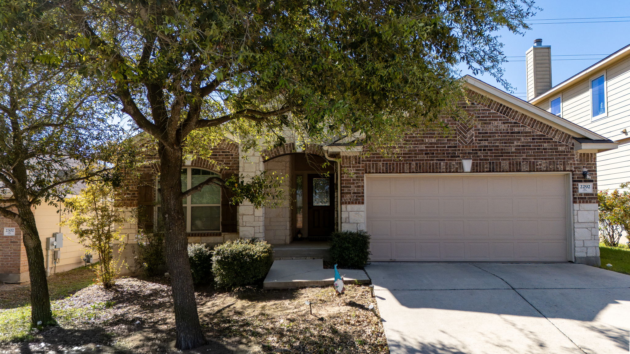 2292 Intrepid Drive Buda, TX 78610 - Photo 29 of 38 View of front facade with an attached garage, driveway, stone siding, and brick siding
