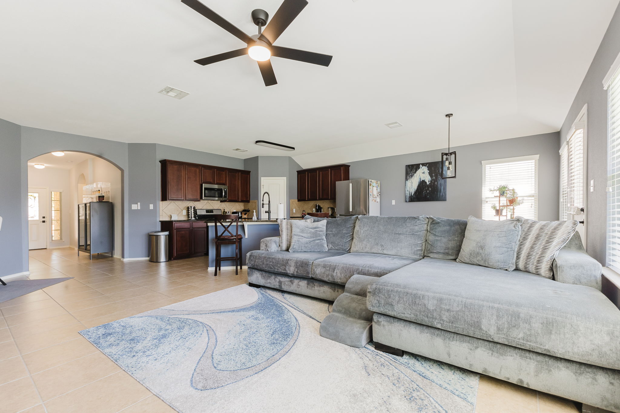 2292 Intrepid Drive Buda, TX 78610 - Photo 3 of 38 Living area with arched walkways, a ceiling fan, and light tile patterned floors