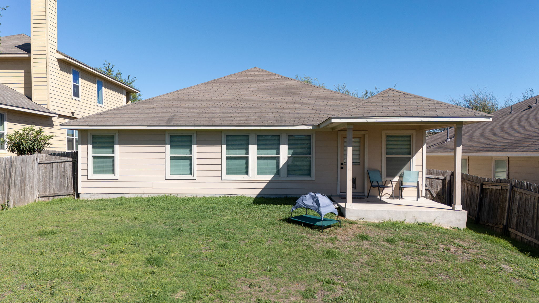 2292 Intrepid Drive Buda, TX 78610 - Photo 35 of 38 Rear view of house with a fenced backyard, a patio area, and roof with shingles