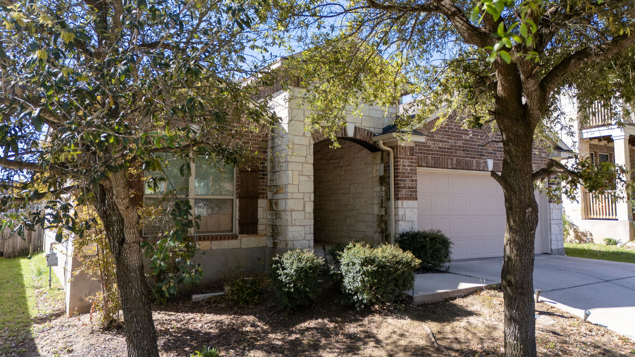 2292 Intrepid Drive Buda, TX 78610 - Photo 37 of 38 View of side of home with stone siding, concrete driveway, and a garage