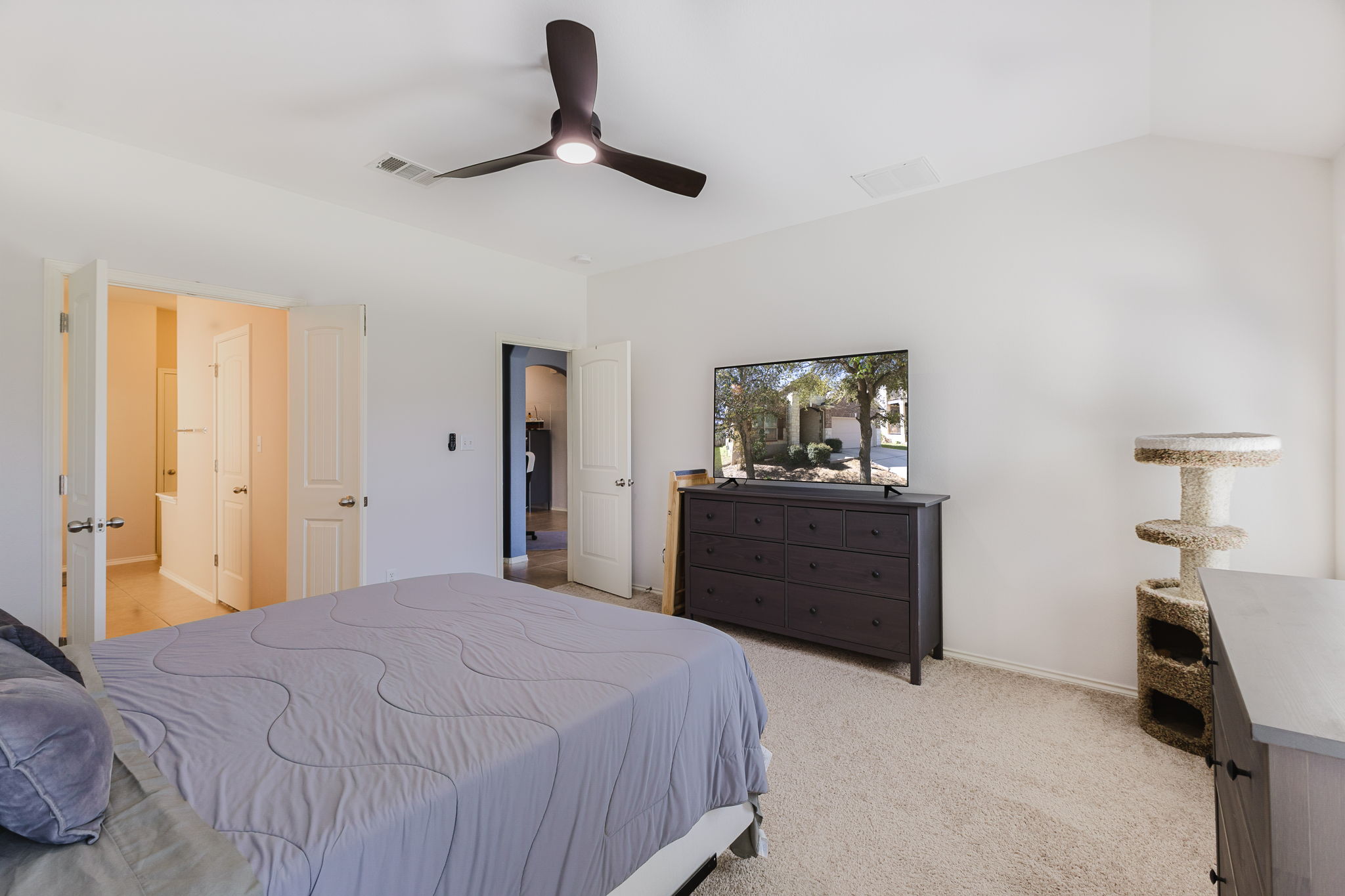 2292 Intrepid Drive Buda, TX 78610 - Photo 8 of 38 Bedroom with light colored carpet, ceiling fan, and vaulted ceiling