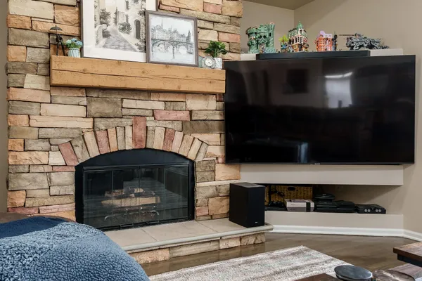 a living room with a fireplace a rug and a window