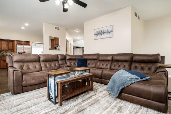 a living room with furniture and a ceiling fan
