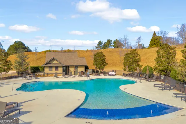 a view of a house with pool and chairs