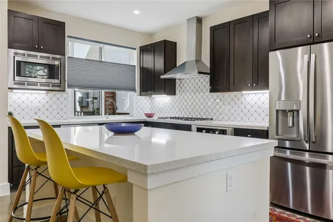 a kitchen with stainless steel appliances a sink a stove a refrigerator and cabinets