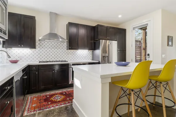 a kitchen with stainless steel appliances granite countertop a sink and a refrigerator