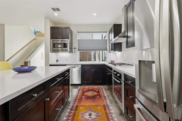a kitchen with stainless steel appliances granite countertop a sink and stove
