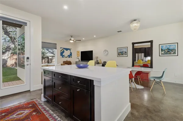 a living room with a couch and a dining table with wooden floor