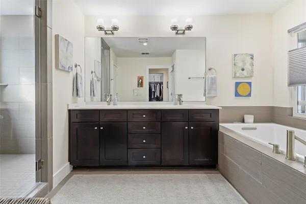 a spacious bathroom with a tub double sink and mirror